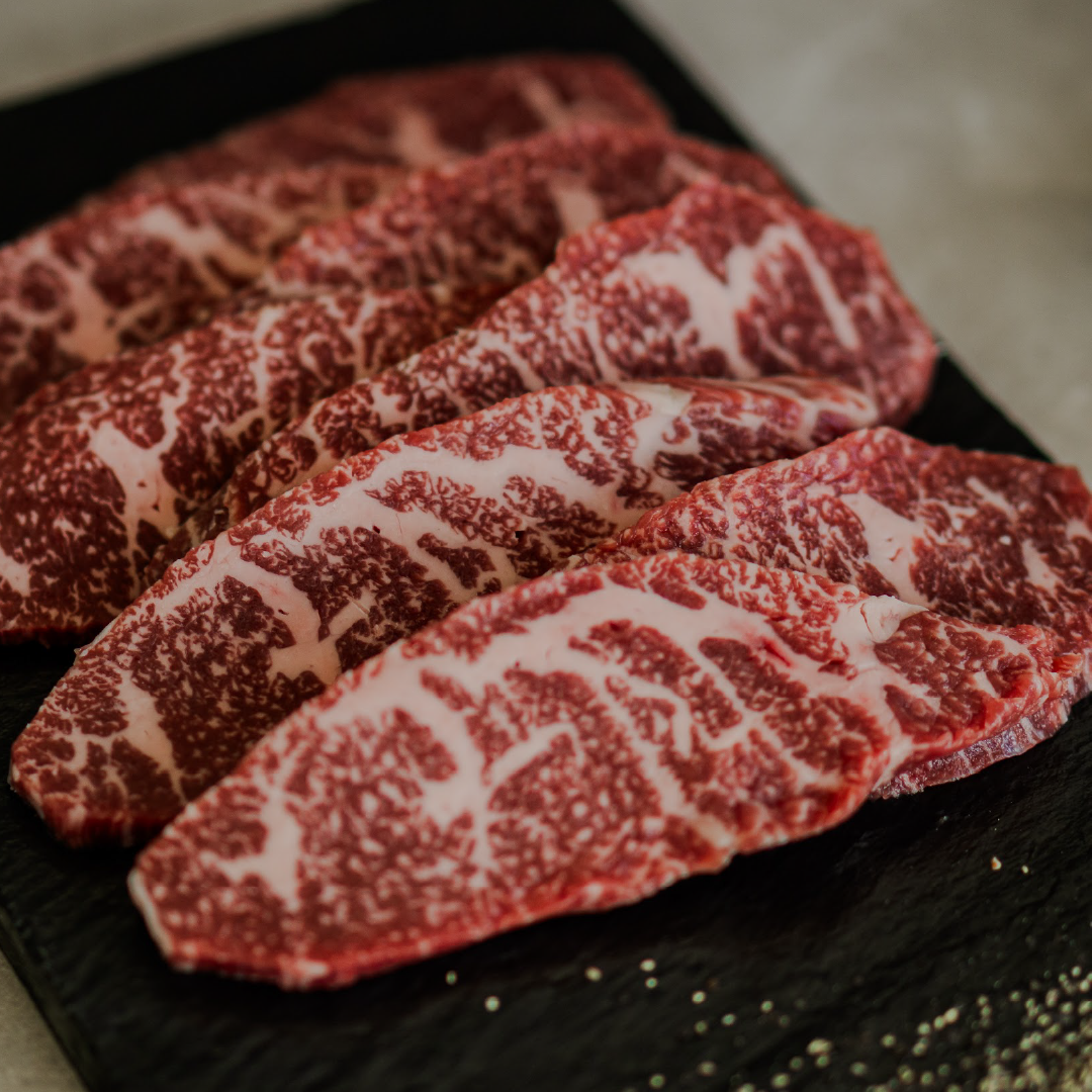 Slices of marbled wagyu on a dark surface